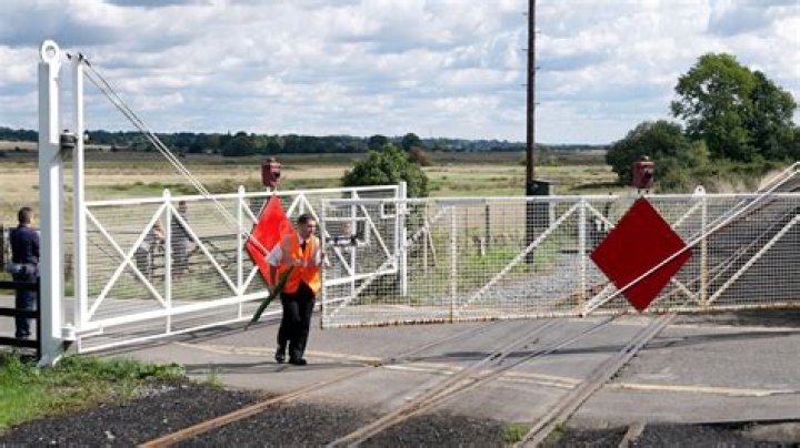 What is a level crossing with a gate sign and what does it mean?